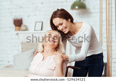 Positive woman taking care of her disabled grandmother Royalty-Free Stock Photo #529634521