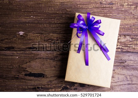 Present gift box design wrapped in color paper with bows on a wooden background.View from above with copy space.Christmas and New Year background,