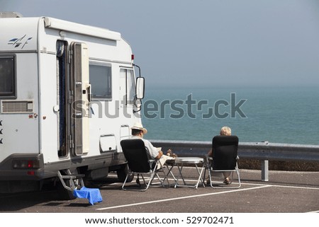 Rear view of two people resting at seafront parking in Folkestone. Kent, England, United Kingdom.