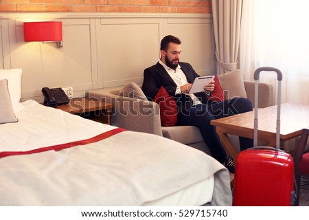 Picture showing tired businessman relaxing in hotel room