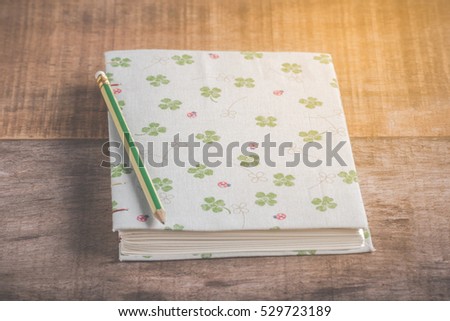 Closeup of handmade book and pencil on wooden background
