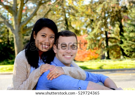 Young attractive couple in love in an autumn setting following their engagement