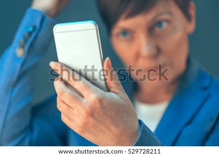 Businesswoman making selfie photo portrait with mobile smart phone in office