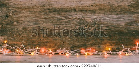 festive wooden background from old boards with lights. with space for text. the concept of a new year, Christmas. tinted photo.