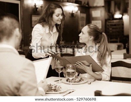 Handsome man with beautiful girlfriend making order in the cafe