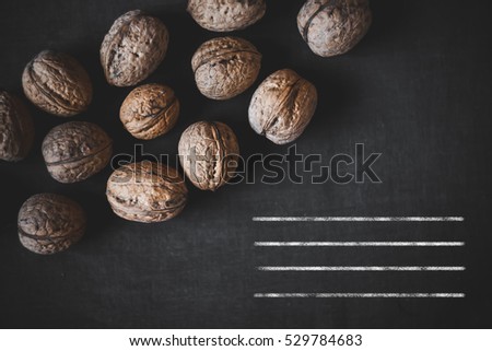 Many walnuts on a black background. Place for text. Autumn.