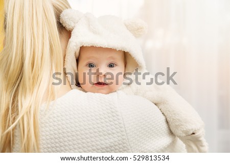 mother with her baby in fluffy bear costume over shoulder