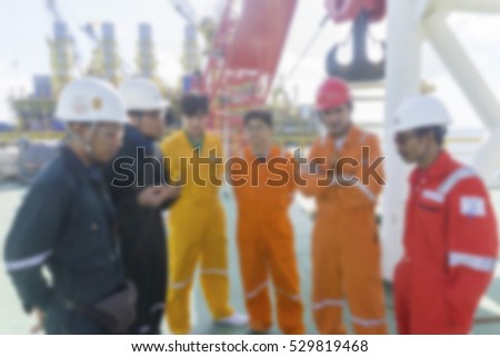 Discussion session. Men with coveralls discussing on site. Motion blur effect.