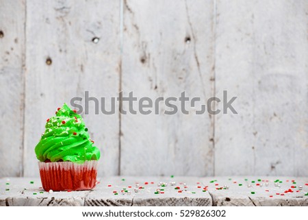 Bright red cupcakes in the form of Christmas trees on a white wooden background