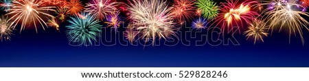 Lively multi-colored fireworks on dark blue background in panorama format, ideal for New Year or other celebration events