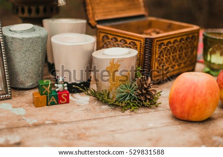 silver frame standing on the table. in the frame of the picture drawn by the pen. the pattern of the ornament . on the table is a wooden box and red Apple