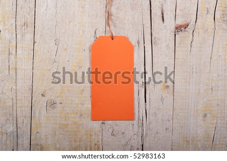 Blank orange paper tag on Grungy Wood Background