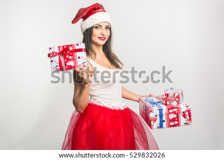 Young adorable brunette woman in a white shirt and red skirt of tulle holds (brags gives, receives) New Year's gift. On a white background. Mock up. Human. New Year. Christmas.