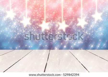 Blue Christmas Background with Golden hanging stars and  glitter or bokeh lights. Round defocused particles. White table 