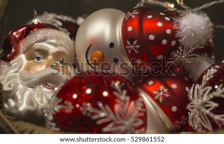 Beautiful red and white christmas tree decorations shaped like santa claus and a smiling snowman with wool cap