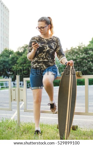 Young girl sitting on the street and leafing through social networks. Dependence on smartphone