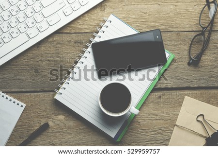 keyboard,phone,coffee and notepad on table