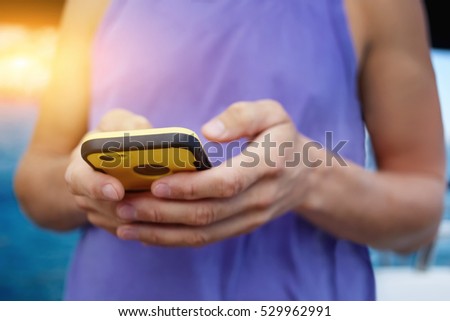 Cropped image of man's hand holding modern smartphone in case while browsing network connection and using online application for sport training activities, share photo and video multimedia files
