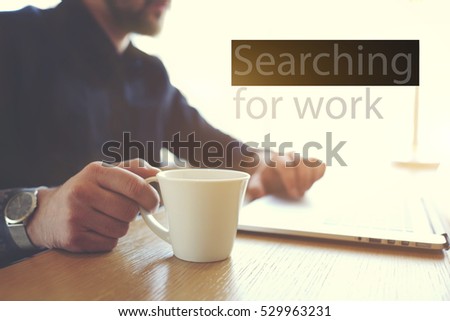 Male freelancer designer creating graphic for cv portfolio using laptop computer and wireless connection to internet sitting on blurred background near copy space. Concept of searching work in network