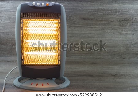 Halogen Electric Stove illuminated and radiating on gray background Royalty-Free Stock Photo #529988512