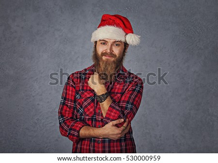 Young handsome smiling excited man in red santa hat isolated on gray grey background. Positive emotion and symbols