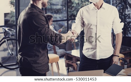 Concept of business partnership handshake.Closeup photo two businessmans handshaking process.Successful deal after great meeting in coworking studio.Horizontal, blurred background