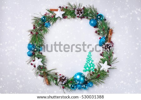 Christmas decoration wreath of pine branches, cones, Christmas balls and paper Christmas trees on white background