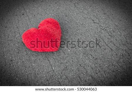 Red fabric heart on road