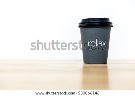 Paper coffee cup on wood table and white background. Relax.