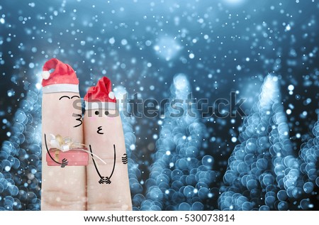 Couple finger with hat santa claus and gift on hand with snow holiday christmas art abstract background