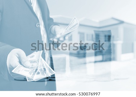 Businessman with money in hand, US dollar (USD) bills on blurred home background ,loans concept