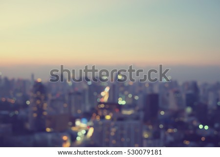 abstract blurred sky night city building of downtown construction with bokeh light background with vintage color effect.