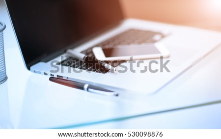 Closeup picture of a keyboard with a phone  lying above it