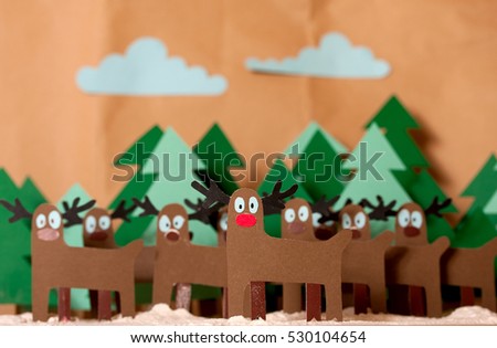 Team Reindeer Santa Claus standing in snowy forest. The whole picture is cutting out from colored paper