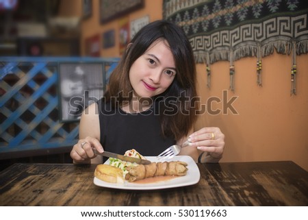 asian woman are eating sausage