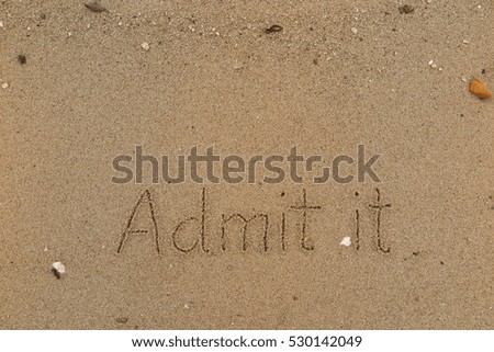 written words "Admit it" on sand of beach