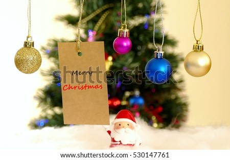 decoration ball with the message car with the word  Merry Christmas  with the blurred background of Decorated Christmas tree