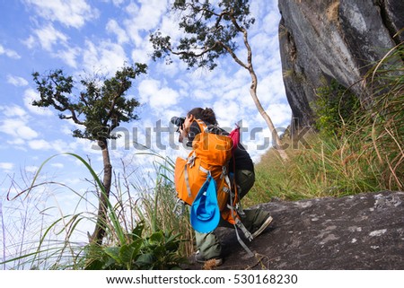 female photographer taking a picture on Mountain