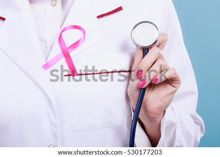Women fight for health. Breast cancer tumor concept. Pink ribbon and blue stethoscope on white medical apron uniform. Doctor holding medic equipment.