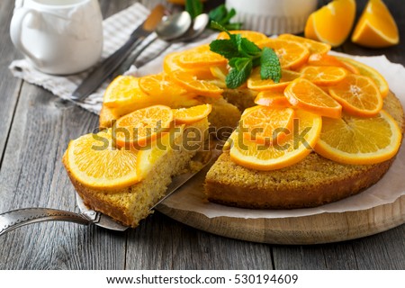 Orange and mandarin cake with polenta, upside down on the old wooden background. Rustic style. Selective focus.
 Royalty-Free Stock Photo #530194609