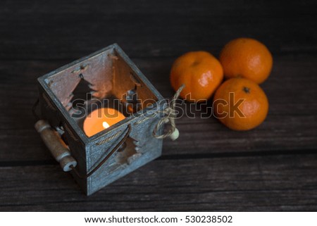 beautiful Christmas candle for a cozy  home and the celebration of Christmas, a wooden candlestick on a dark background 