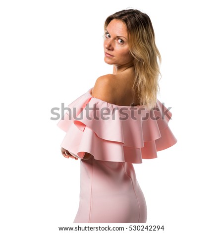 Pretty model woman posing in studio with a pink dress
