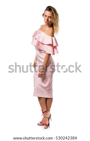Pretty model woman posing in studio with a pink dress