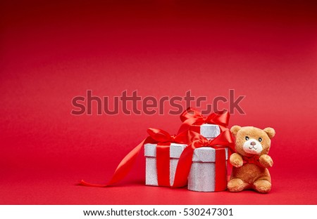 Christmas gifts on red background with toy and ribbons