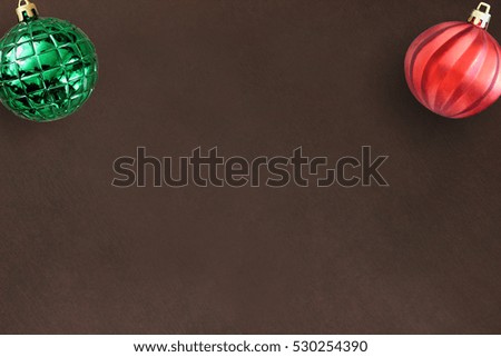 Christmas red wavy and green ribbed ball on dark wooden table. Top view