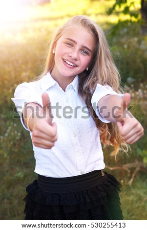 Happy female college student showing thumbs up