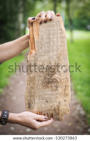 Empty wooden board background hold by woman hand outdoor. Template mock up
