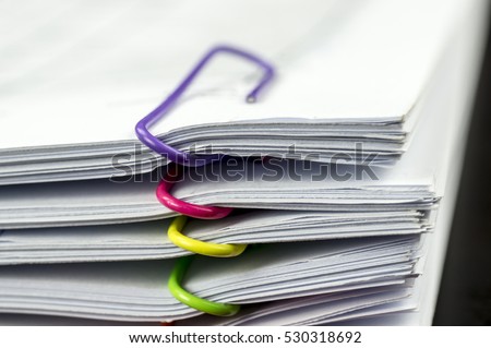 Multicolored paper clips on paperwork Royalty-Free Stock Photo #530318692