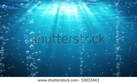 Blue ocean waves from underwater with bubbles. Light rays shining through. Great for backgrounds.