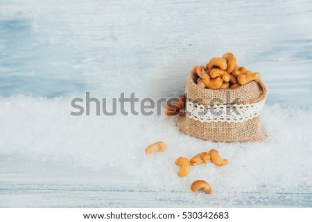 Closeup of sack of cashew over rustic winter wooden background